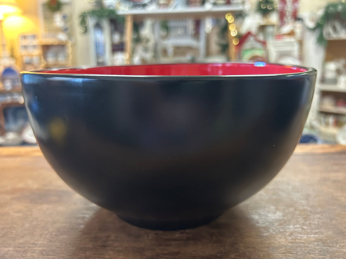 Black ceramic bowl with red interior and thin light-colored rim