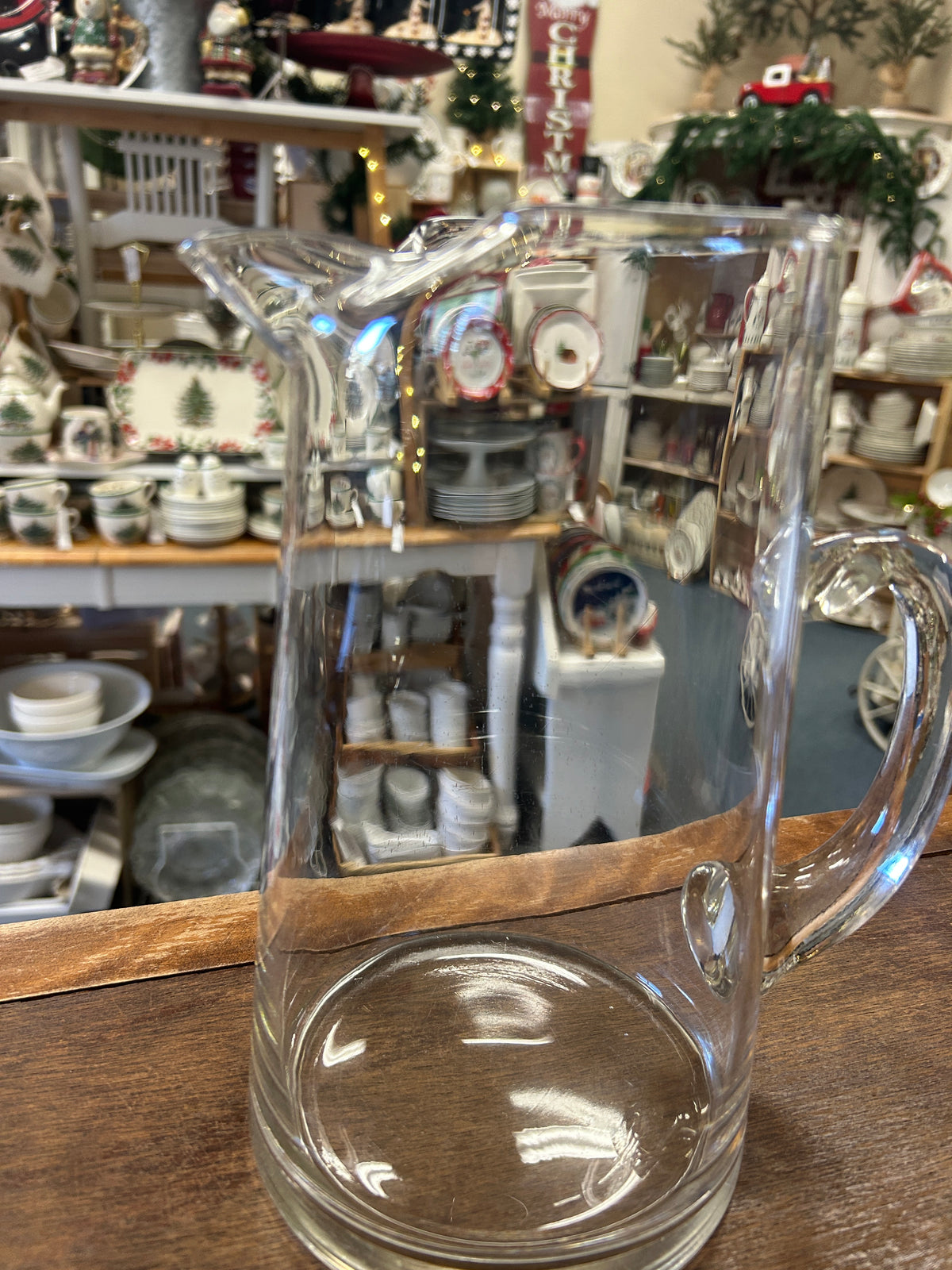 Clear glass pitcher, three-quarter view with wide spout and tall handle