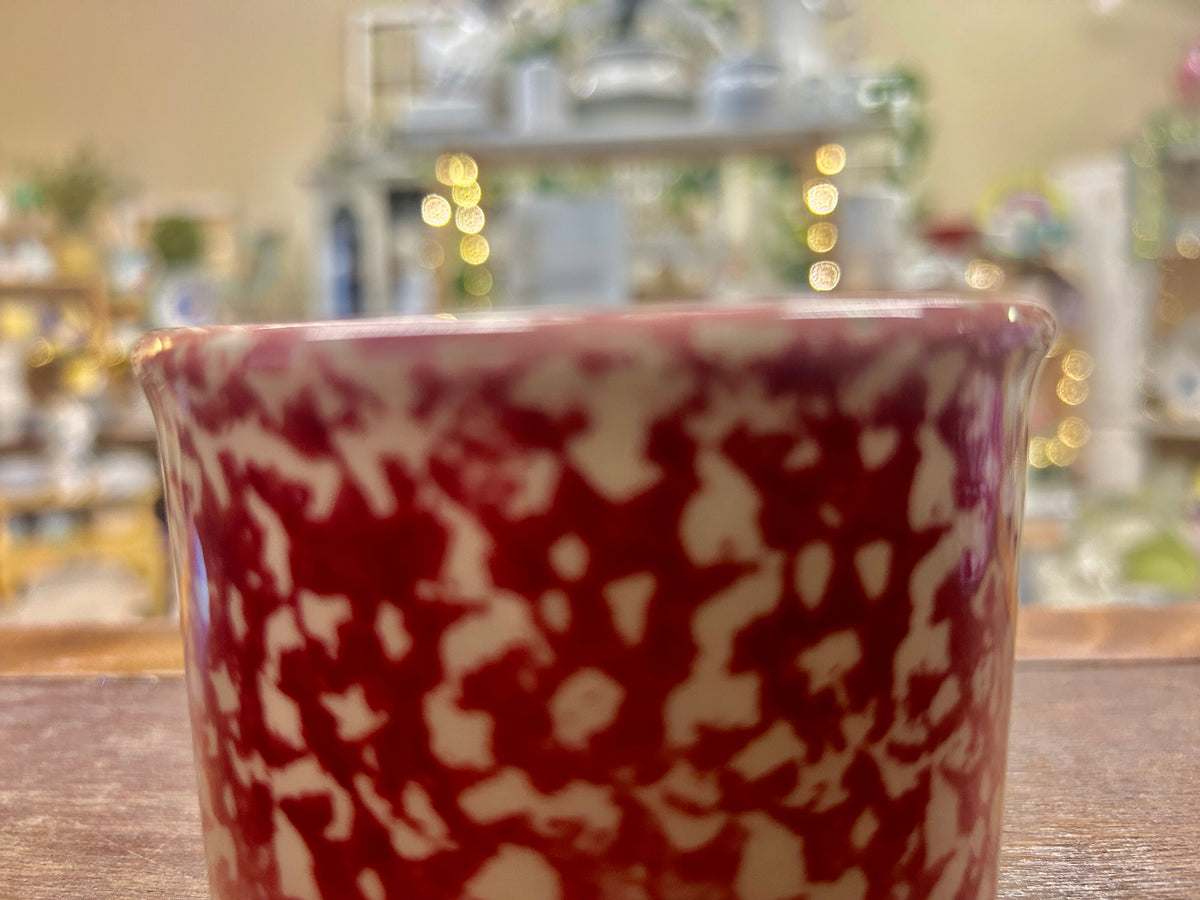 Pink ceramic bowl with marbled red glaze pattern and glossy finish.