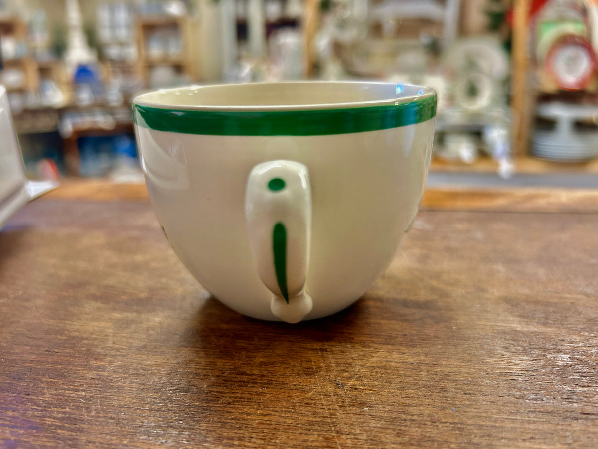 Ceramic Christmas cup with green rim and front red-and-green holiday motif