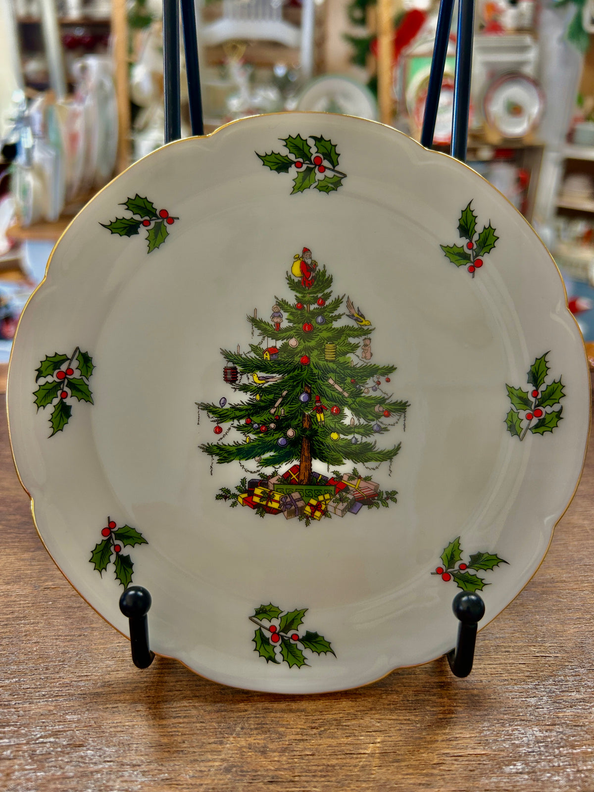 White Christmas plate with gold rim, illustrated tree, holly sprigs, and red accents.