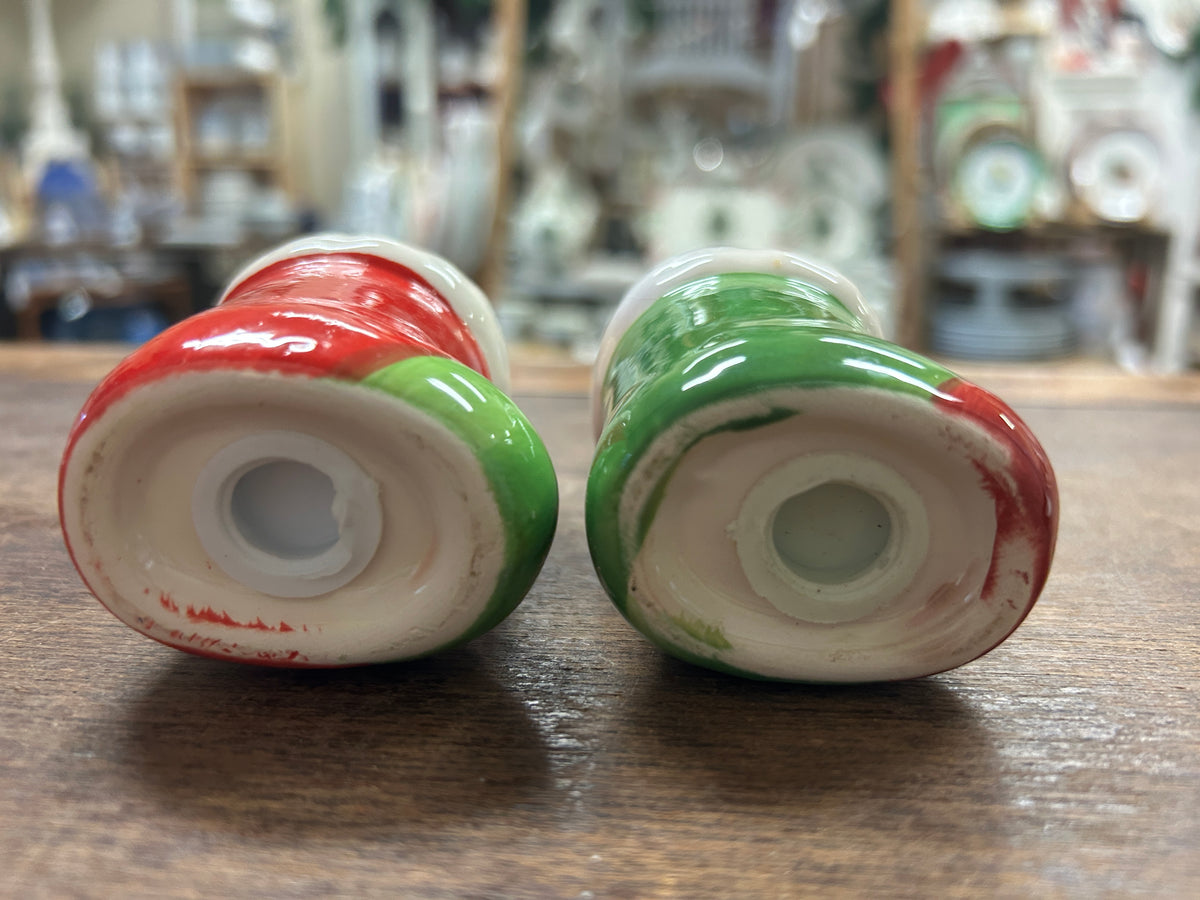 Undersides of red and green dog-shaped salt and pepper shakers with openings