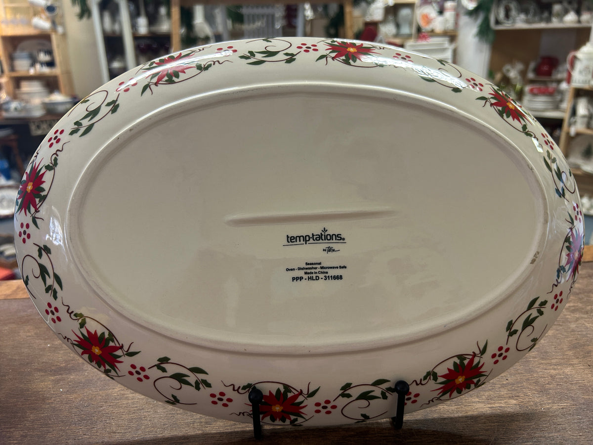 Back of oval ceramic platter with Temptations logo and decorative poinsettia border