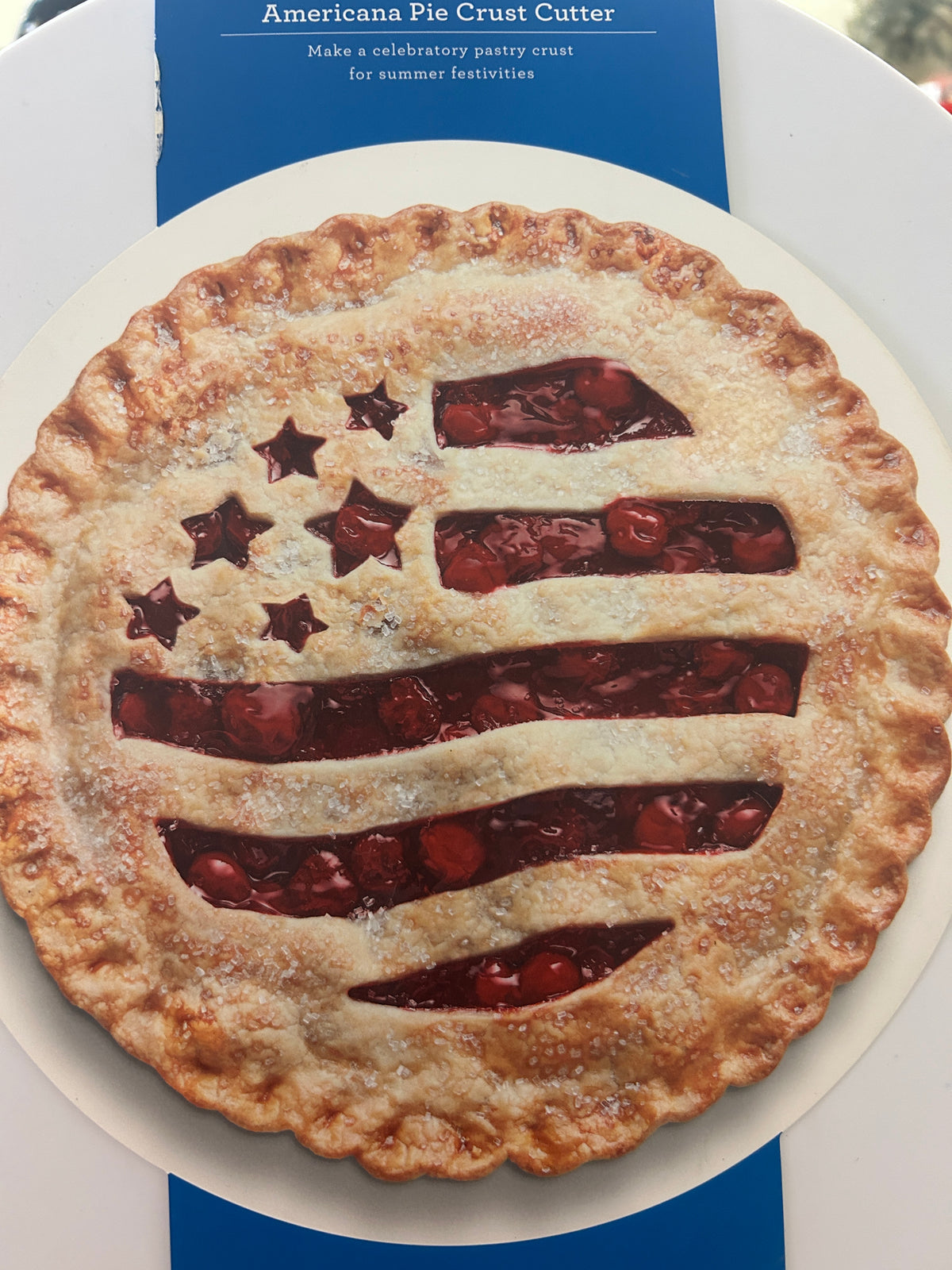 Flag-shaped pie crust cutter on round plate, shown in blue retail package