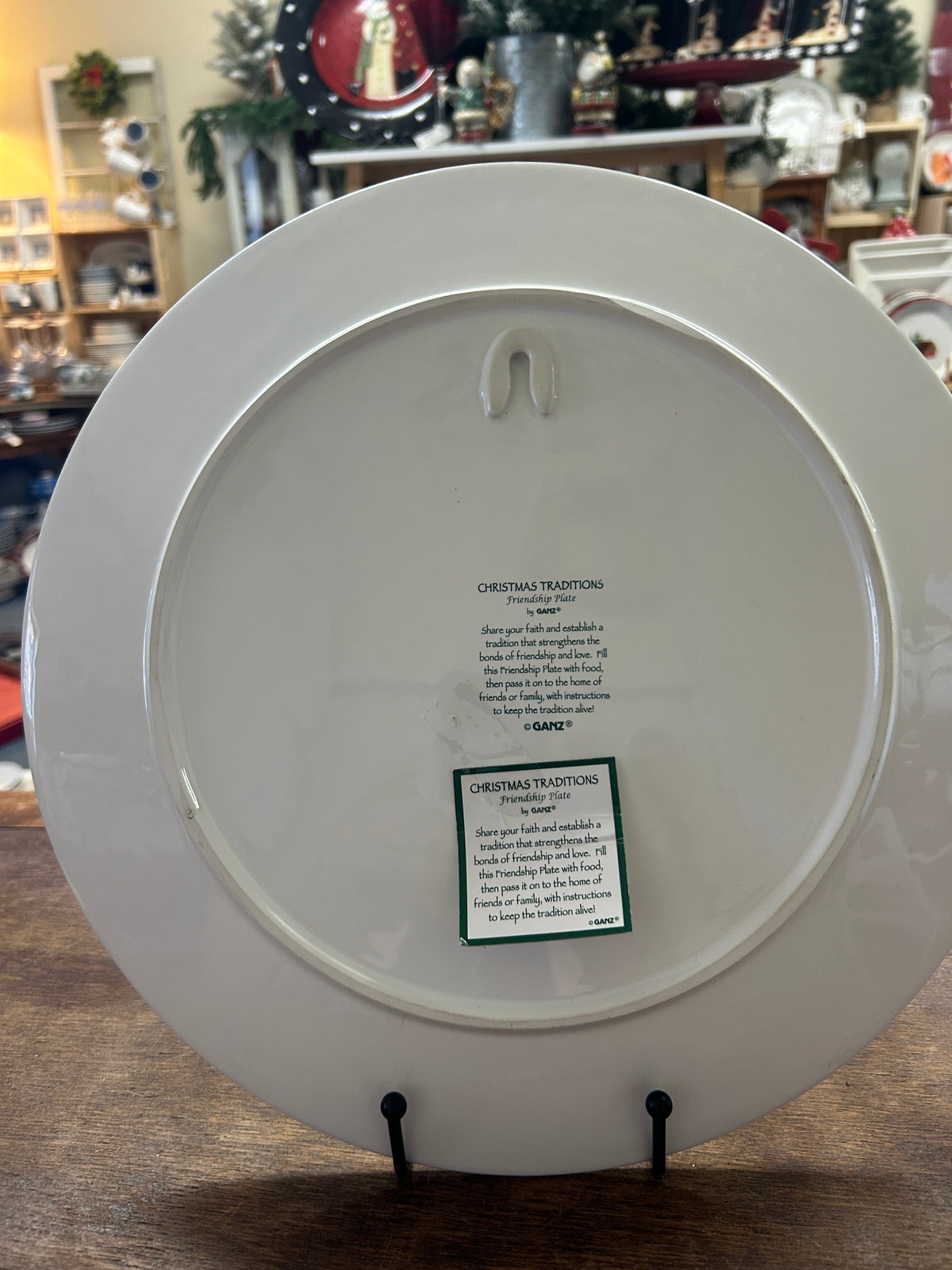White round platter back with small label and hanging hook holes