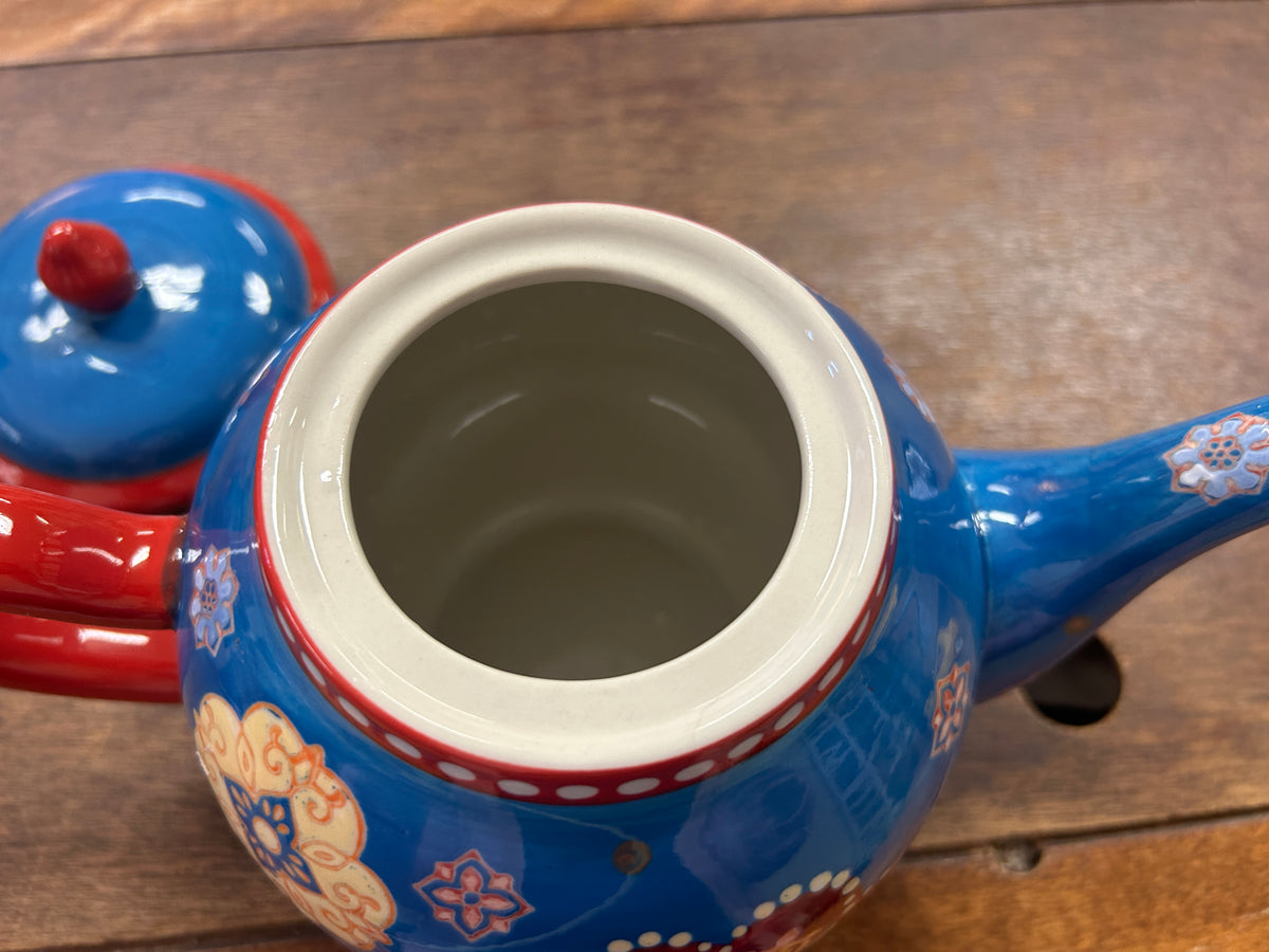 Blue ceramic tea pot with open top showing cream-colored interior rim