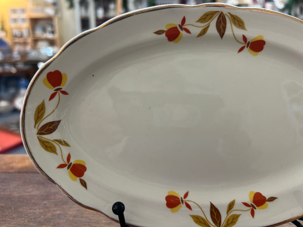 Oval white porcelain gravy plate with autumn leaf pattern and gold rim border
