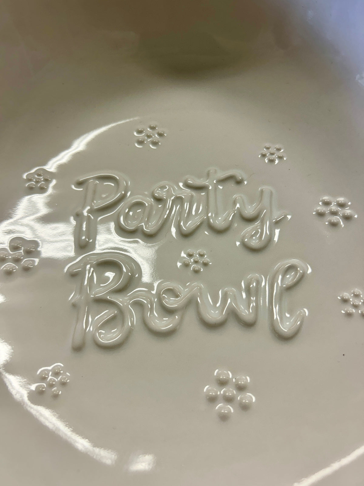 White party bowl with raised 'Party Bowl' script and small embossed flower motifs