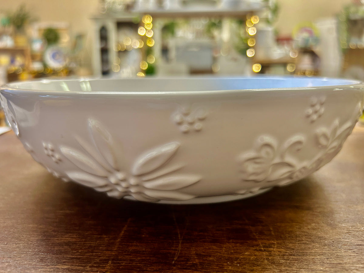 White ceramic party bowl with embossed floral garland detail along the rim