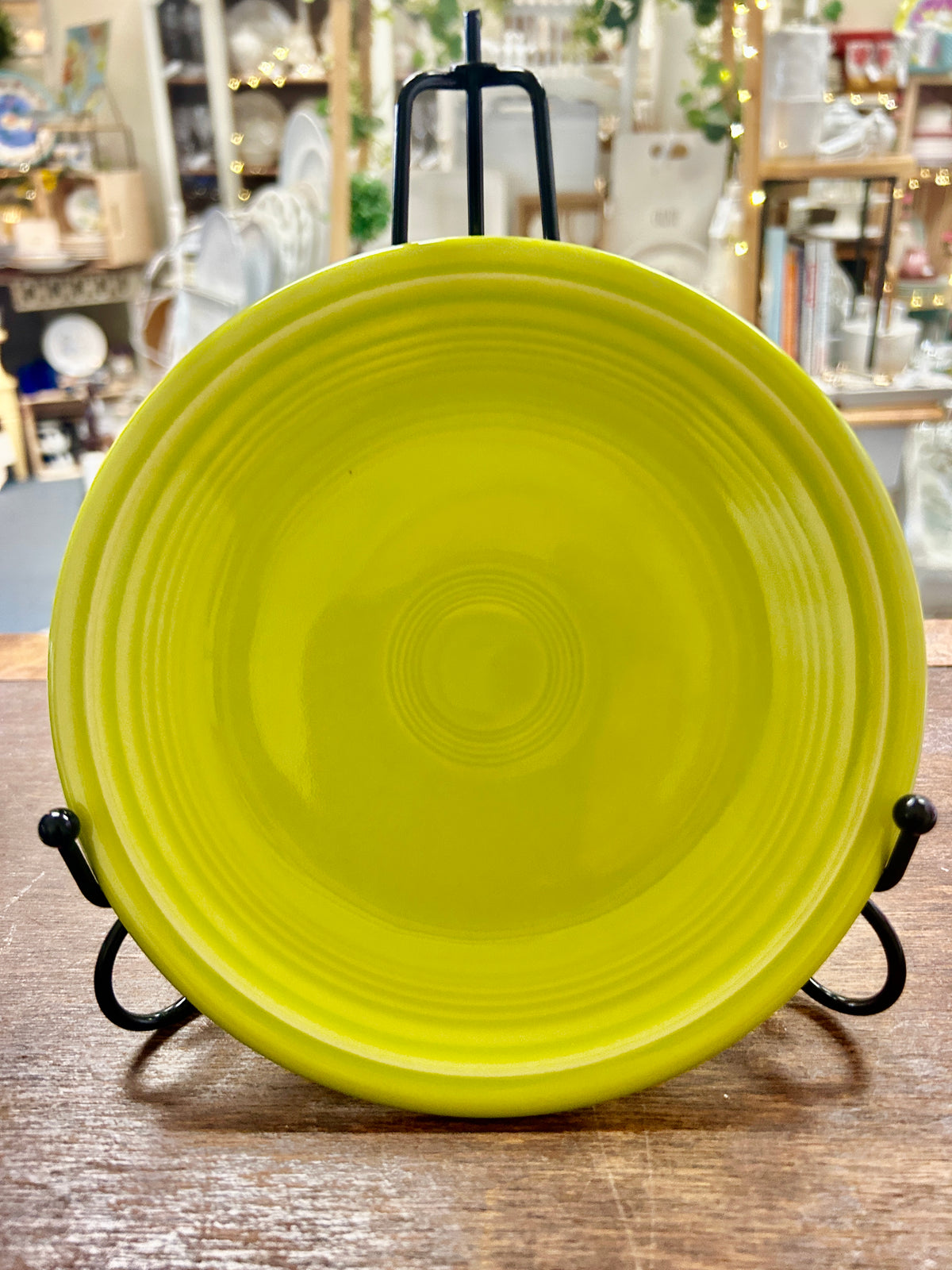 Green 7 1/4 in ceramic plate with ridged rim and center circle, on black stand