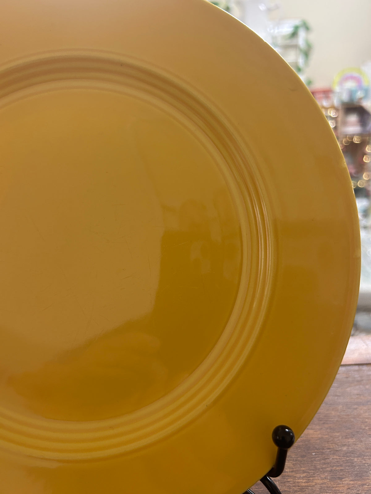 Yellow round ceramic plate, angled close-up of rim and inner rings
