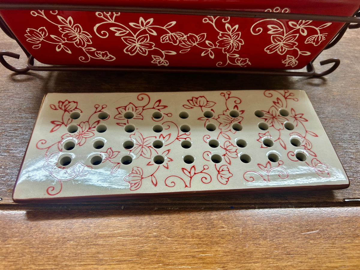 White drip tray with floral sides and metal rack with round vent holes