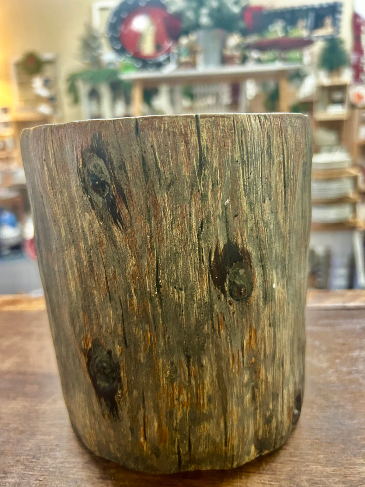 Provencal tree crock showing its weathered, wood-grain exterior and dark knots.