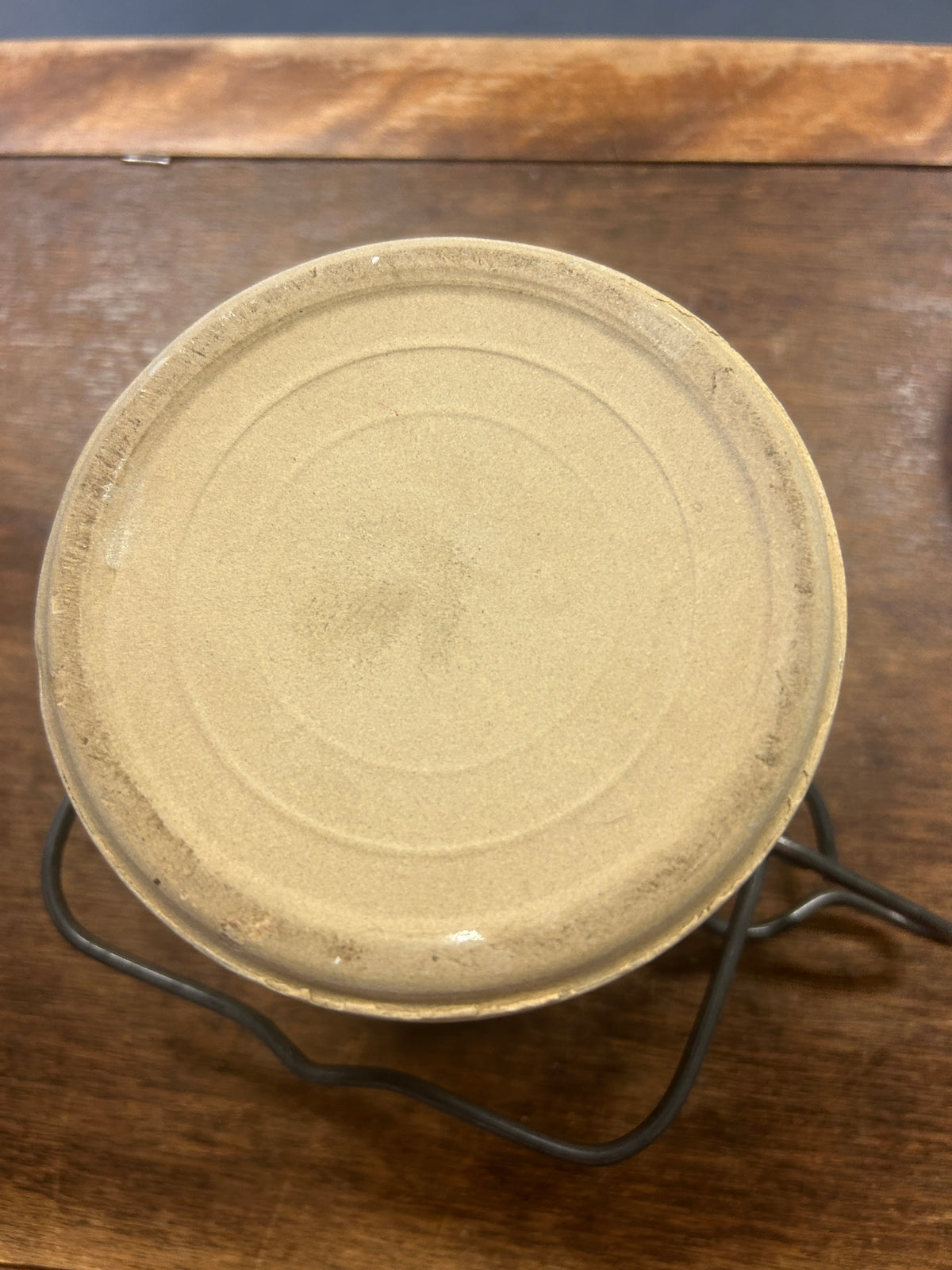 Underside of cream stoneware crock with a circular foot ring