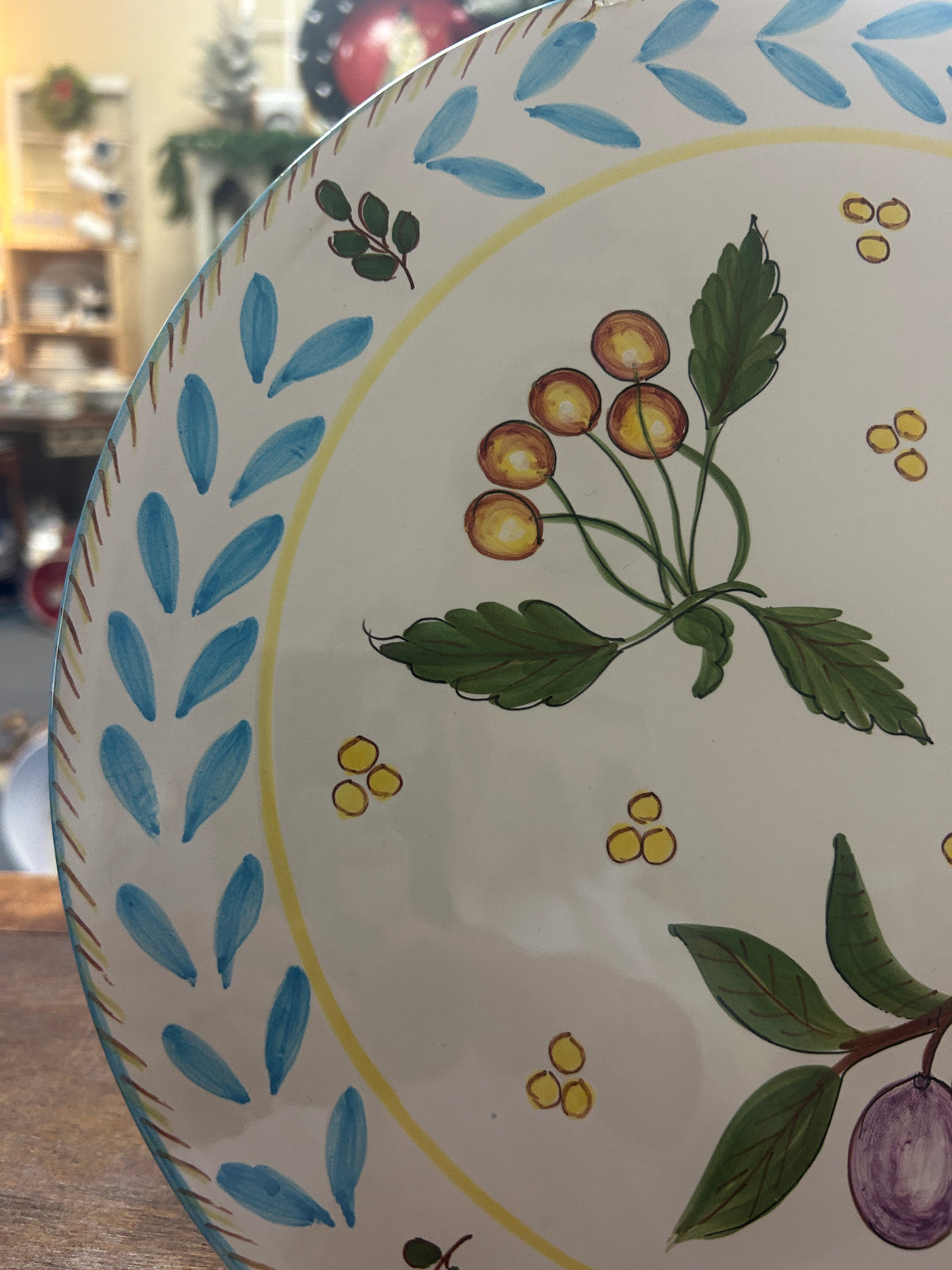 Close-up of platter showing painted berries, leaves, and blue leaf border