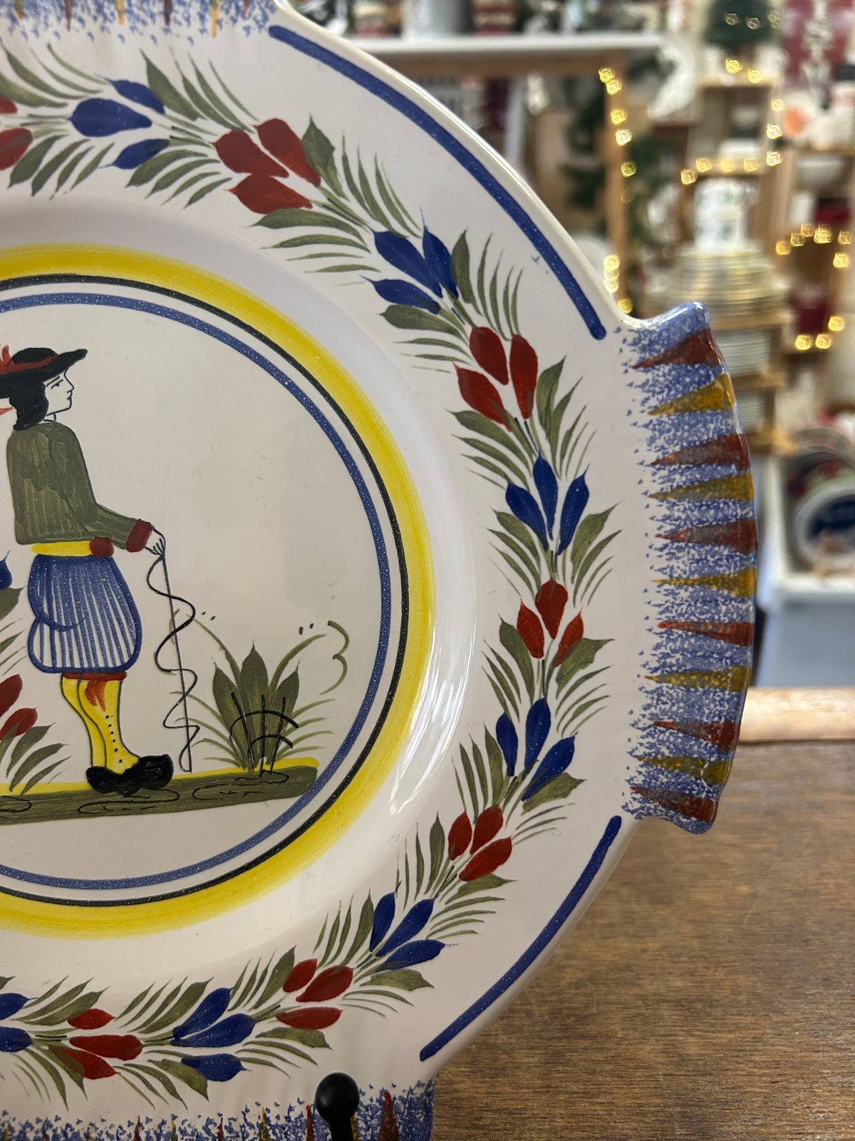Quimper plate detail showing its scalloped rim and painted floral border