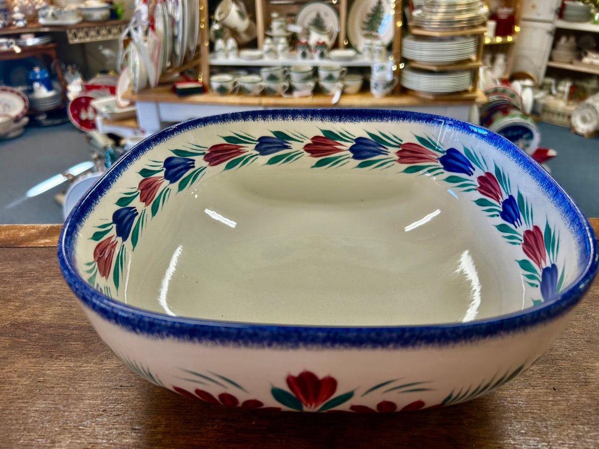 Quimper ceramic serving bowl with floral border and blue rim, shown from above