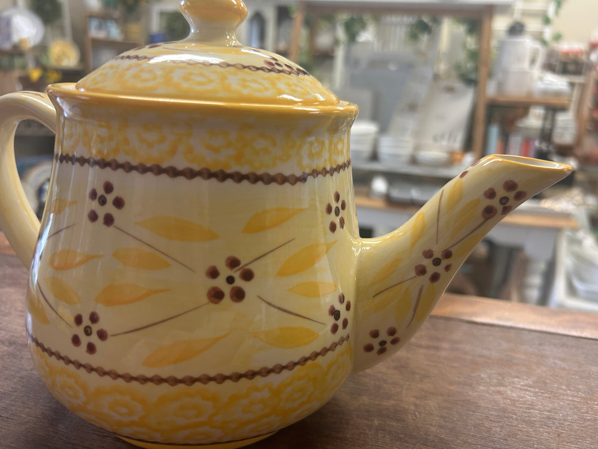 Yellow ceramic teapot with spout, floral and leaf patterned bands