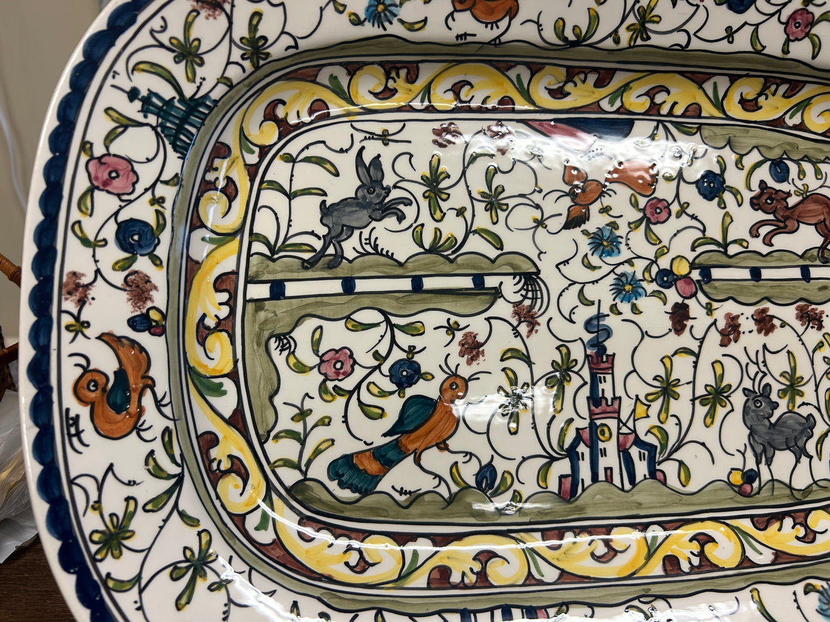 Close-up of multicolor oval ceramic platter with animals, flowers, and castle motifs