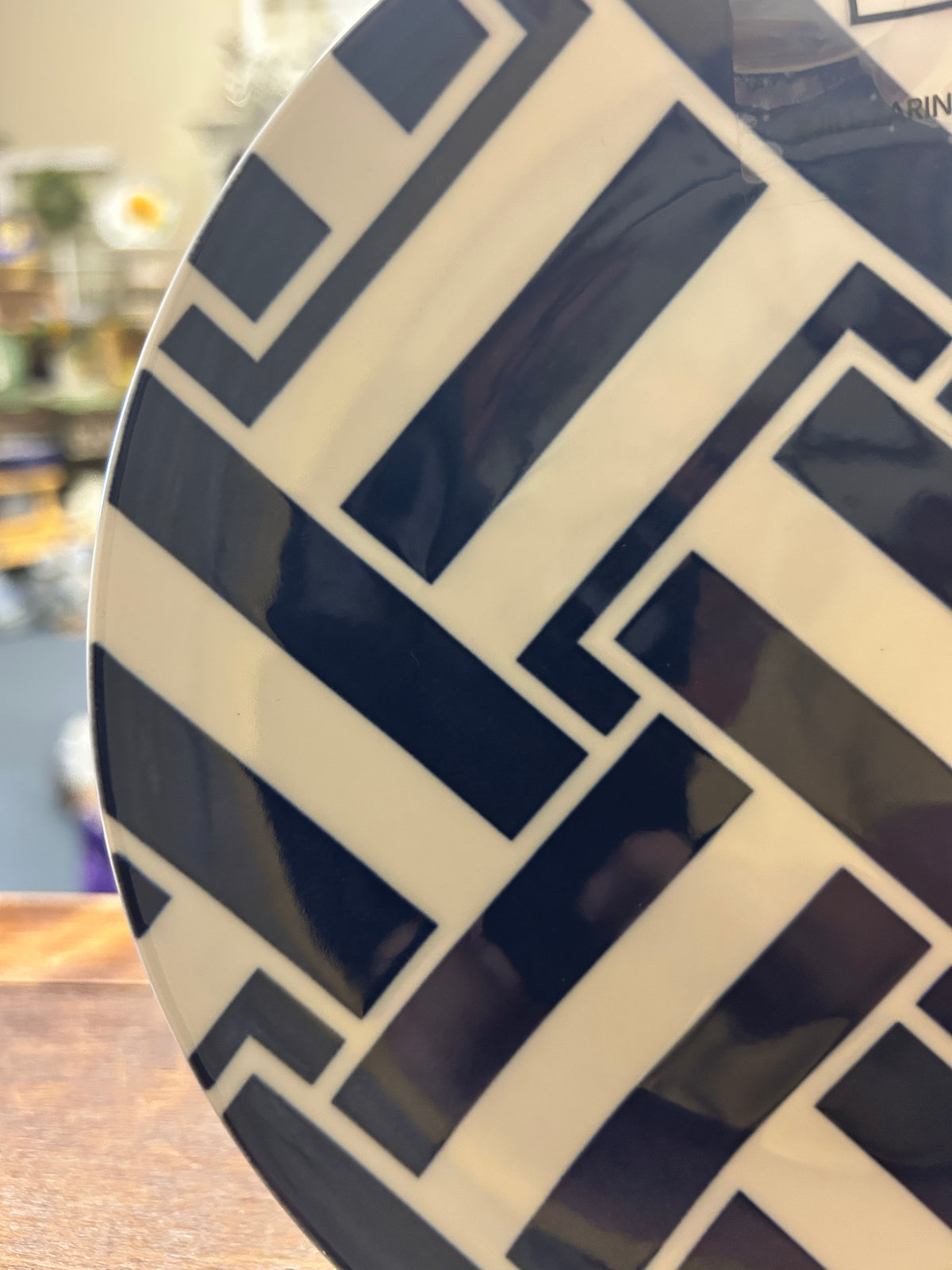 Navy and white Greek key patterned decorative plate, angled view on display stand