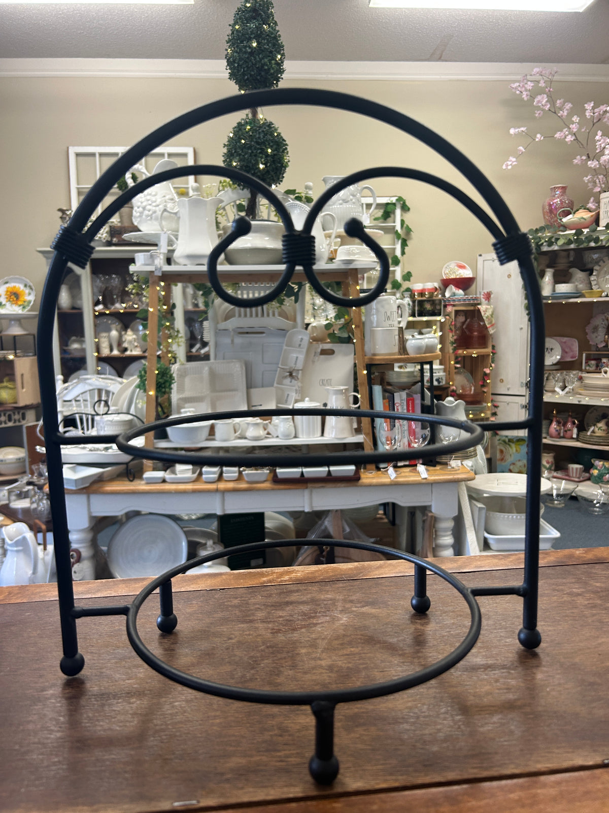 Black two-tier serving stand with arched frame and circular lower tray