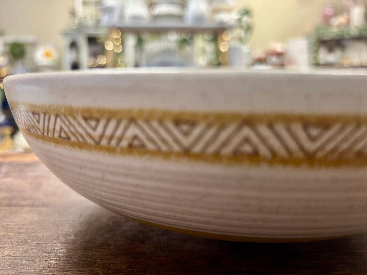 White ceramic bowl with gold geometric band near the rim