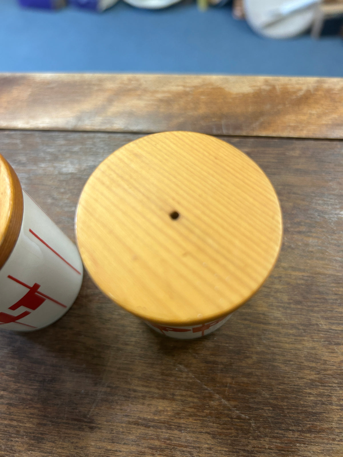 Bamboo jar lid top with one hole; partial red stripe on ceramic body.