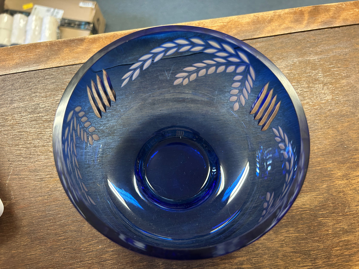 Cobalt blue glass bowl viewed from above with white wheat leaf details.