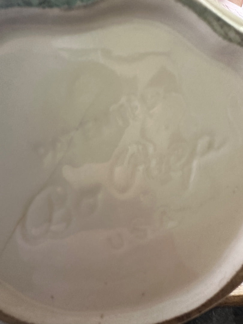 Ceramic pitcher glaze close-up with embossed relief and subtle color staining