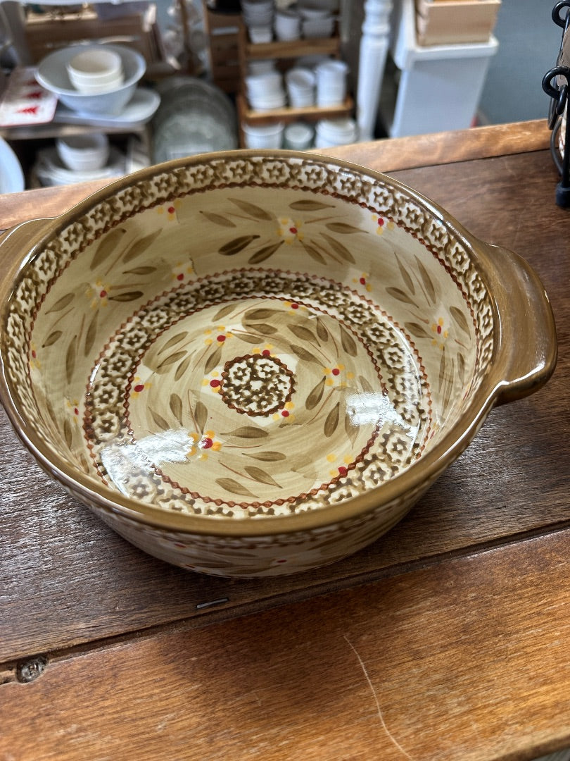 Cream ceramic baker with two loop handles, interior floral ring and border pattern