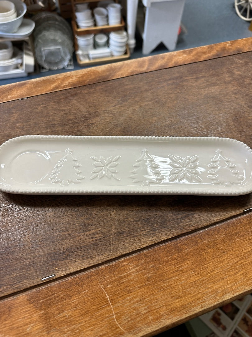 White oval holiday tray with embossed pine trees and snowflake relief pattern
