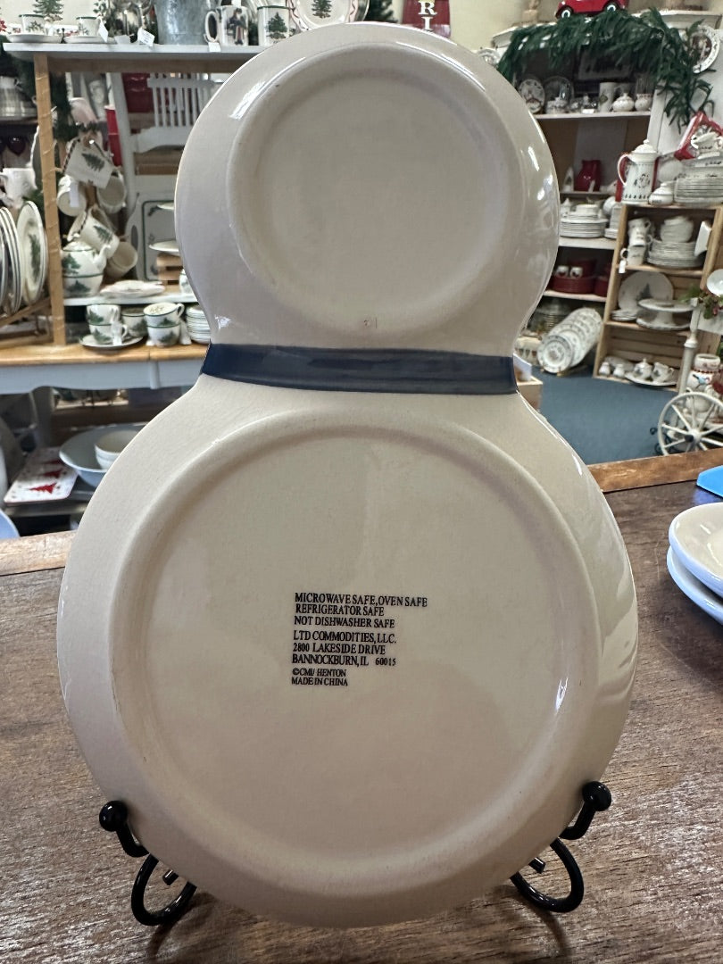 Snowman-shaped ceramic plate back with printed safety text on metal stand