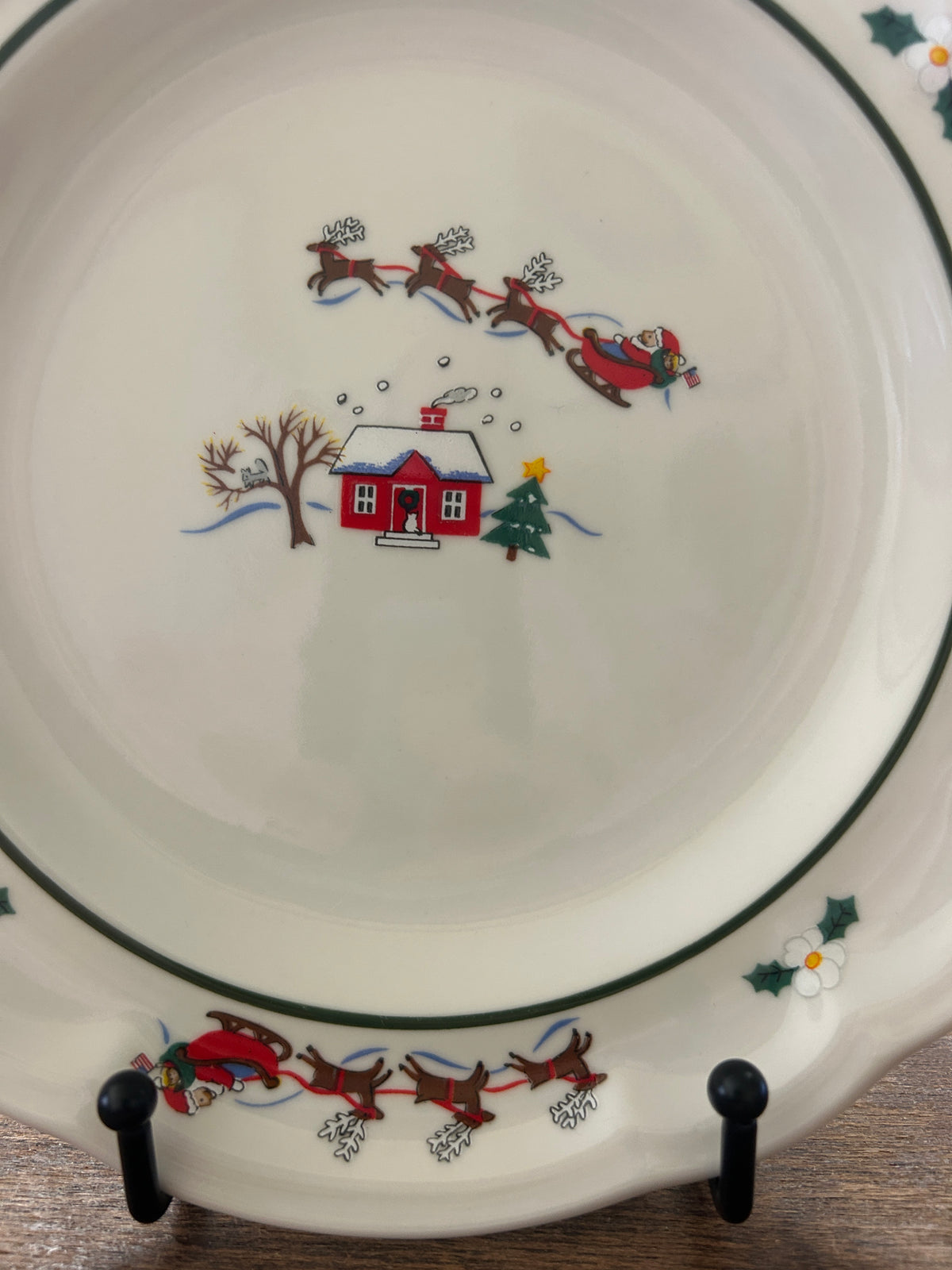Holiday village plate front with red sleigh, farmhouse, pine tree, and snow dots