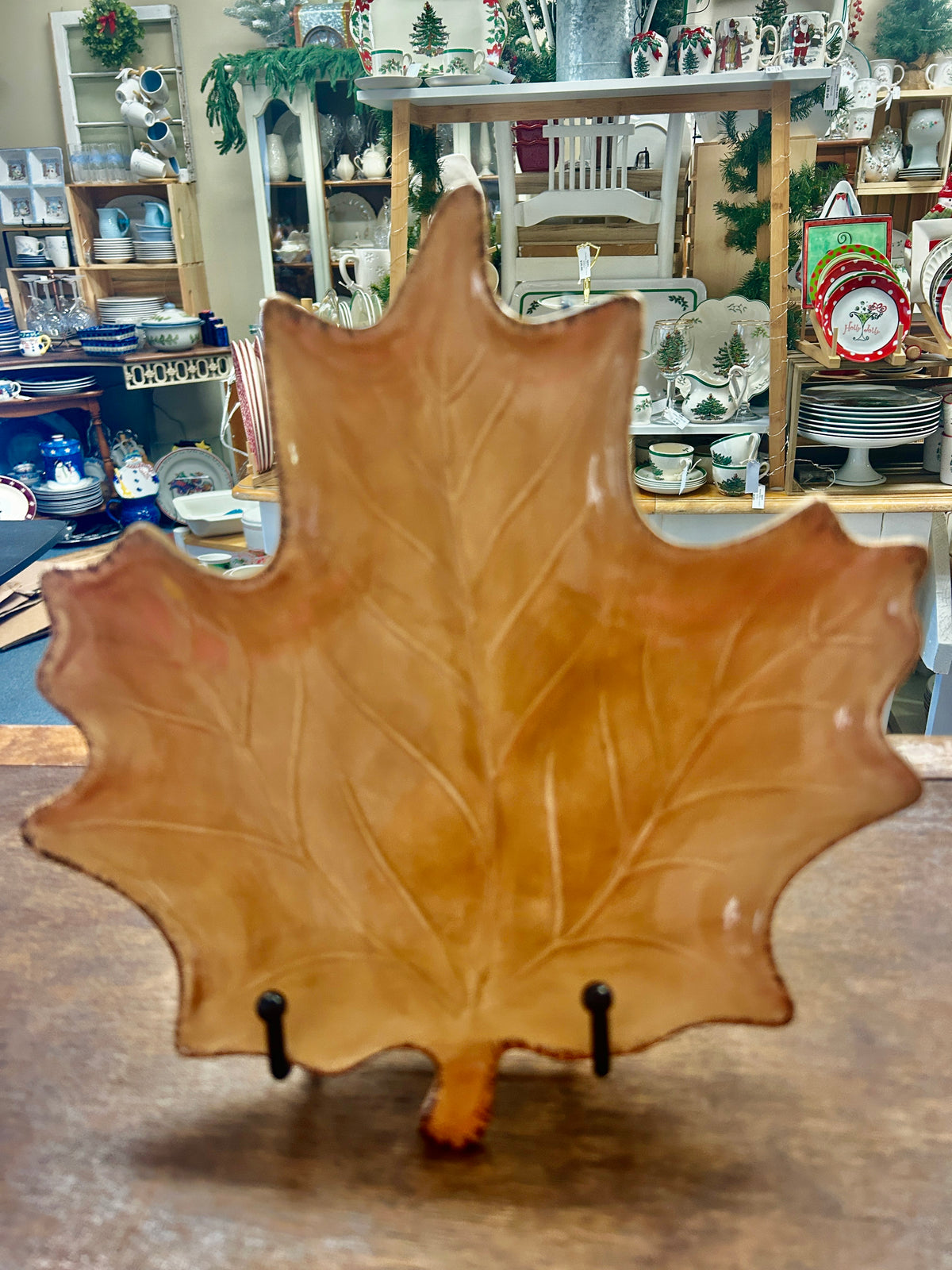 Brown leaf-shaped ceramic serving plate with black stand pegs