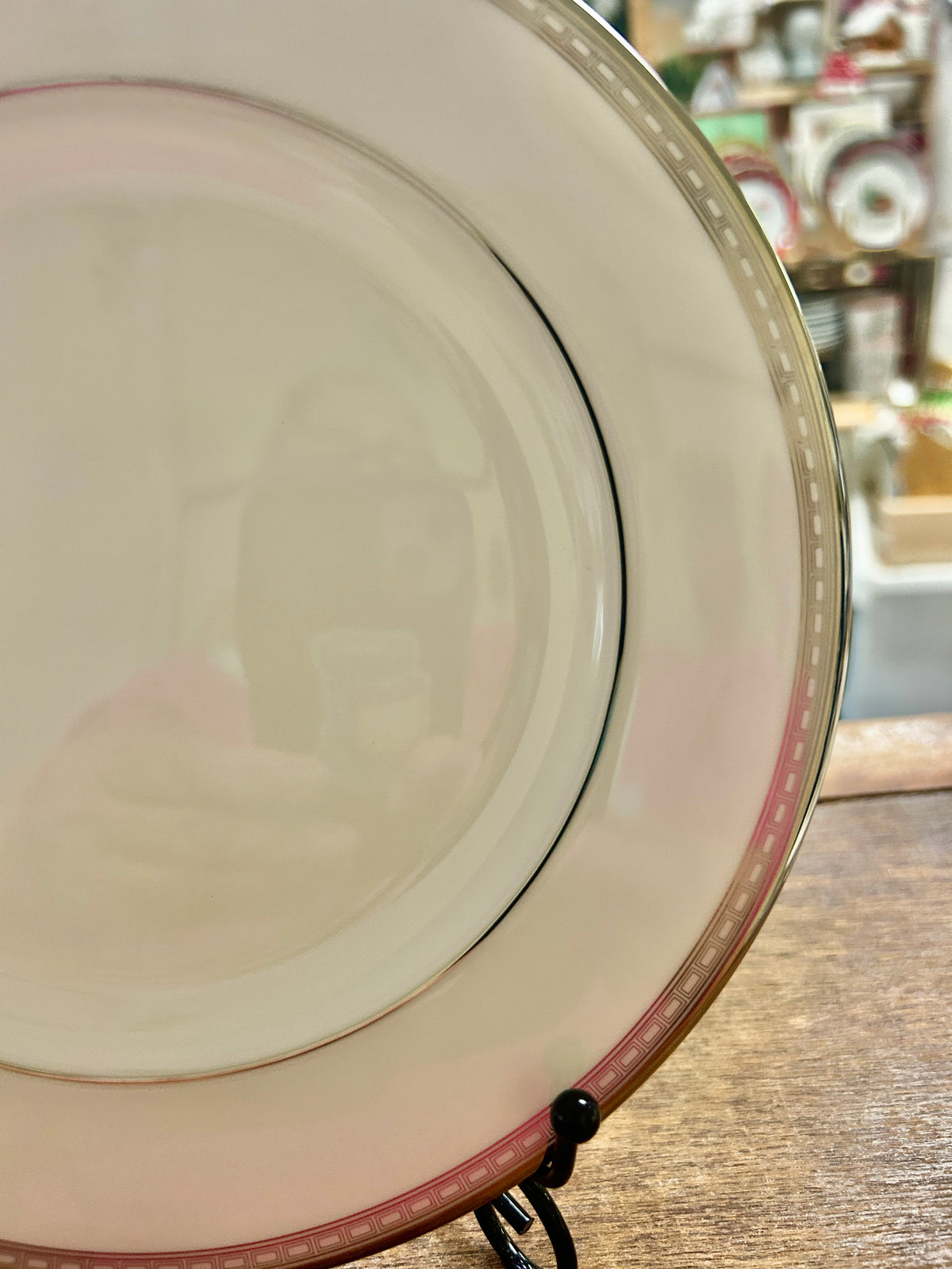 Angle view of cream salad plate with silver rim and red accent line