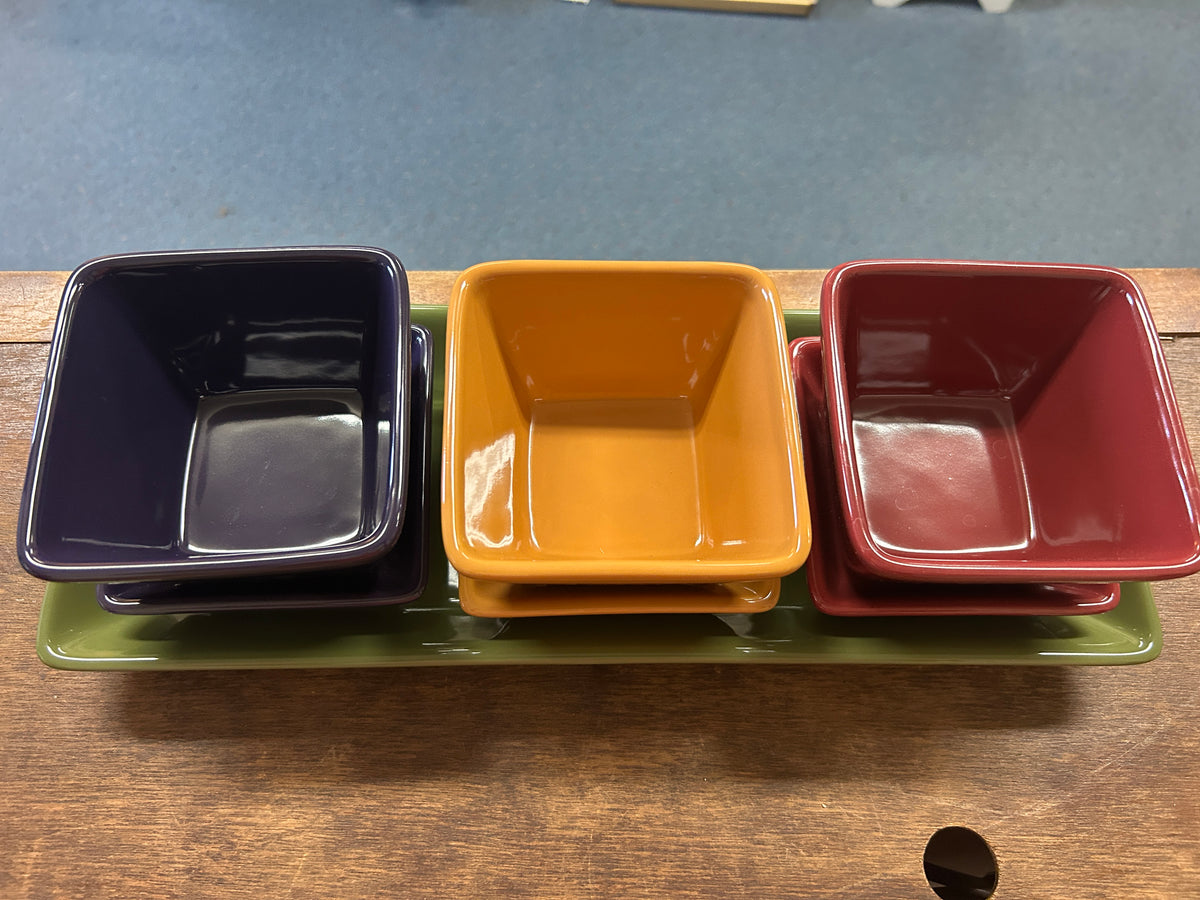 Three square dishes on green tray: navy, orange, and red with glossy finish