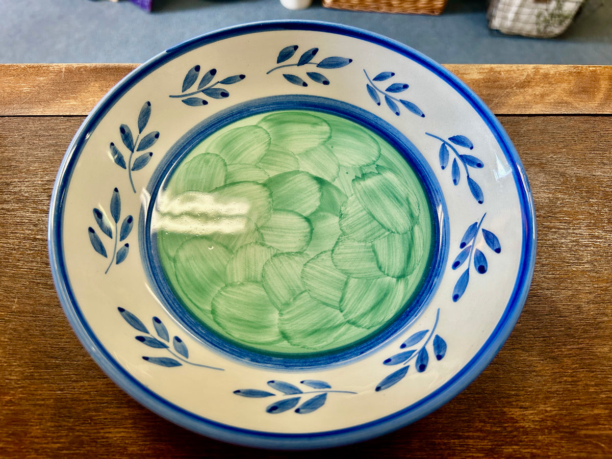 Ceramic bowl with green leaf motif and blue foliate border