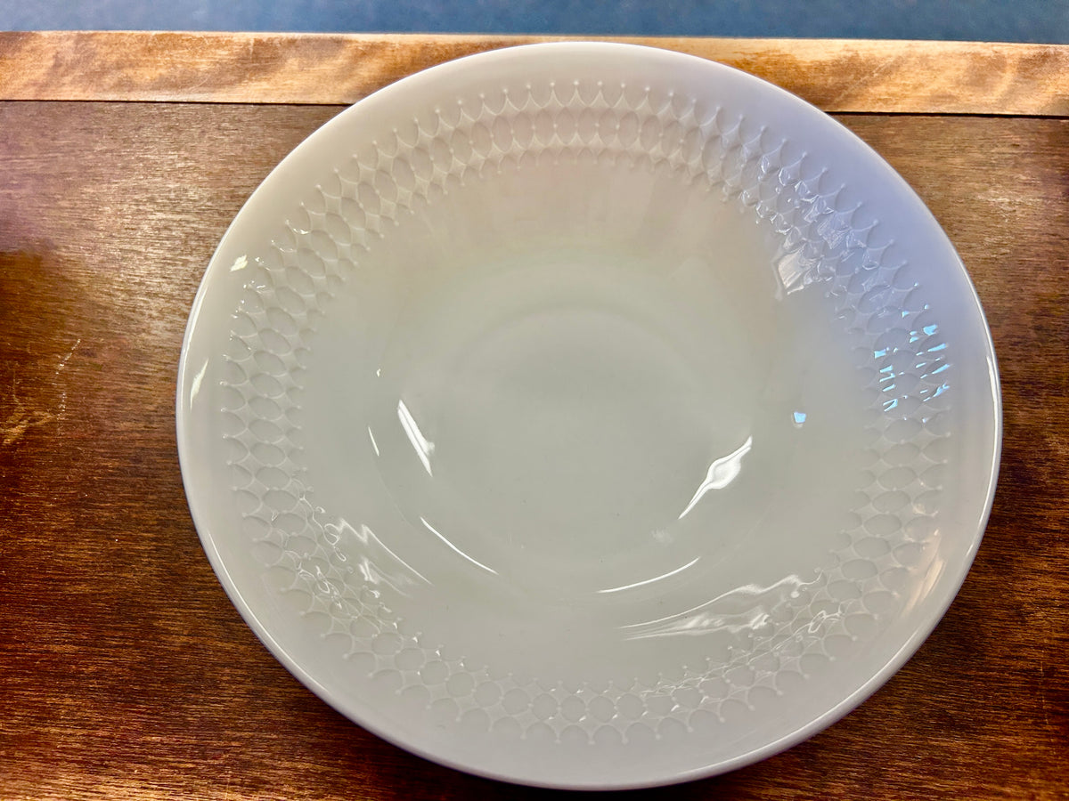 White serving bowl, shallow round shape with raised rim texture