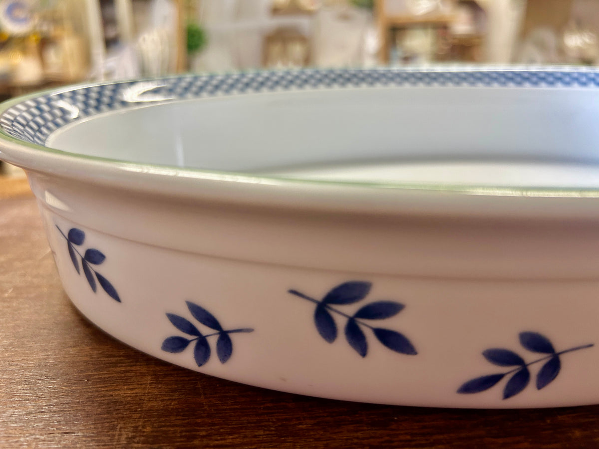 Blue and white oval bowl with navy floral leaf motif along rim
