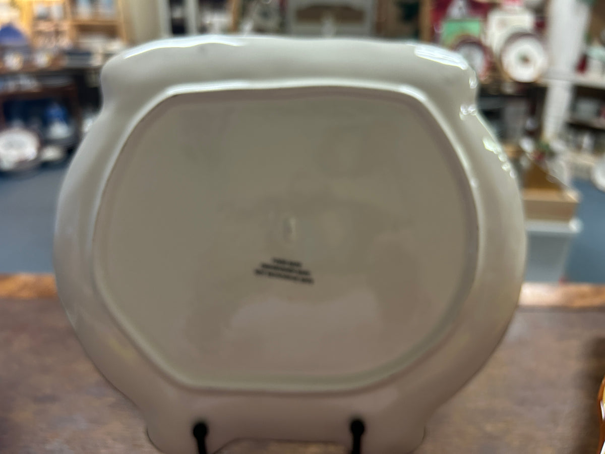 White cauldron platter back with raised rim and small black stand supports