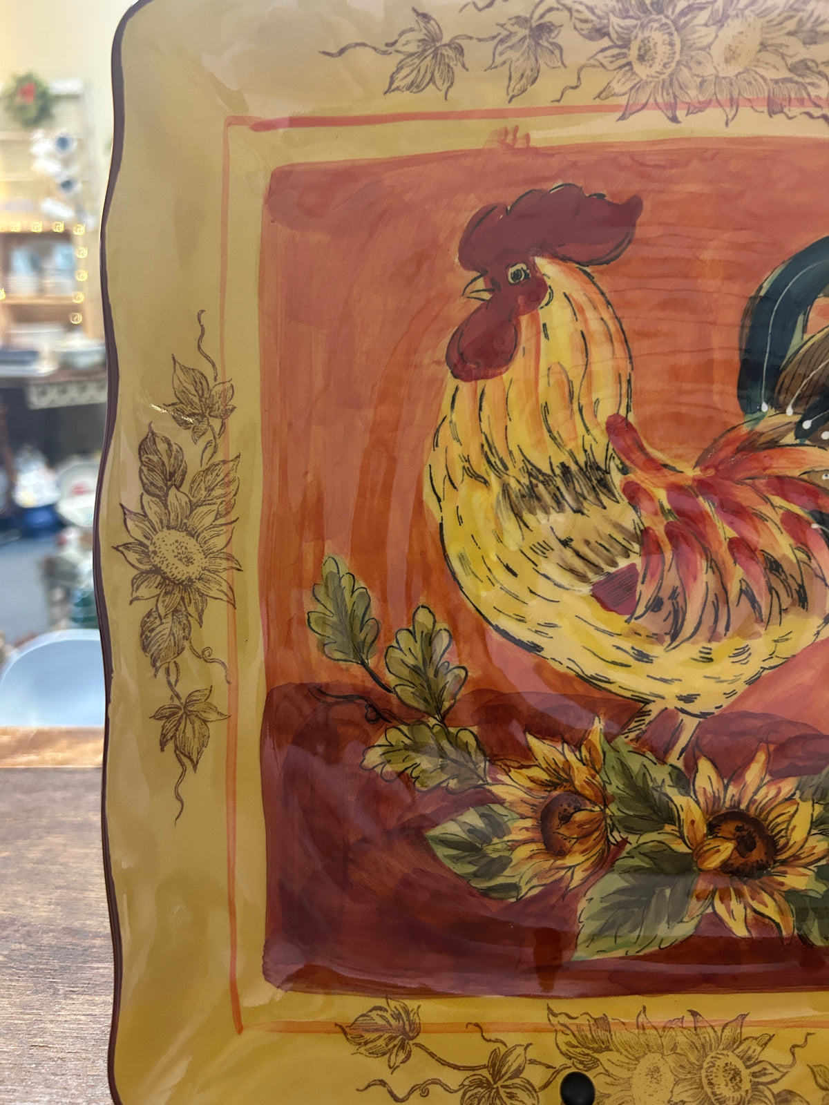 Orange and yellow rooster square platter close view of rooster and flowers in frame.