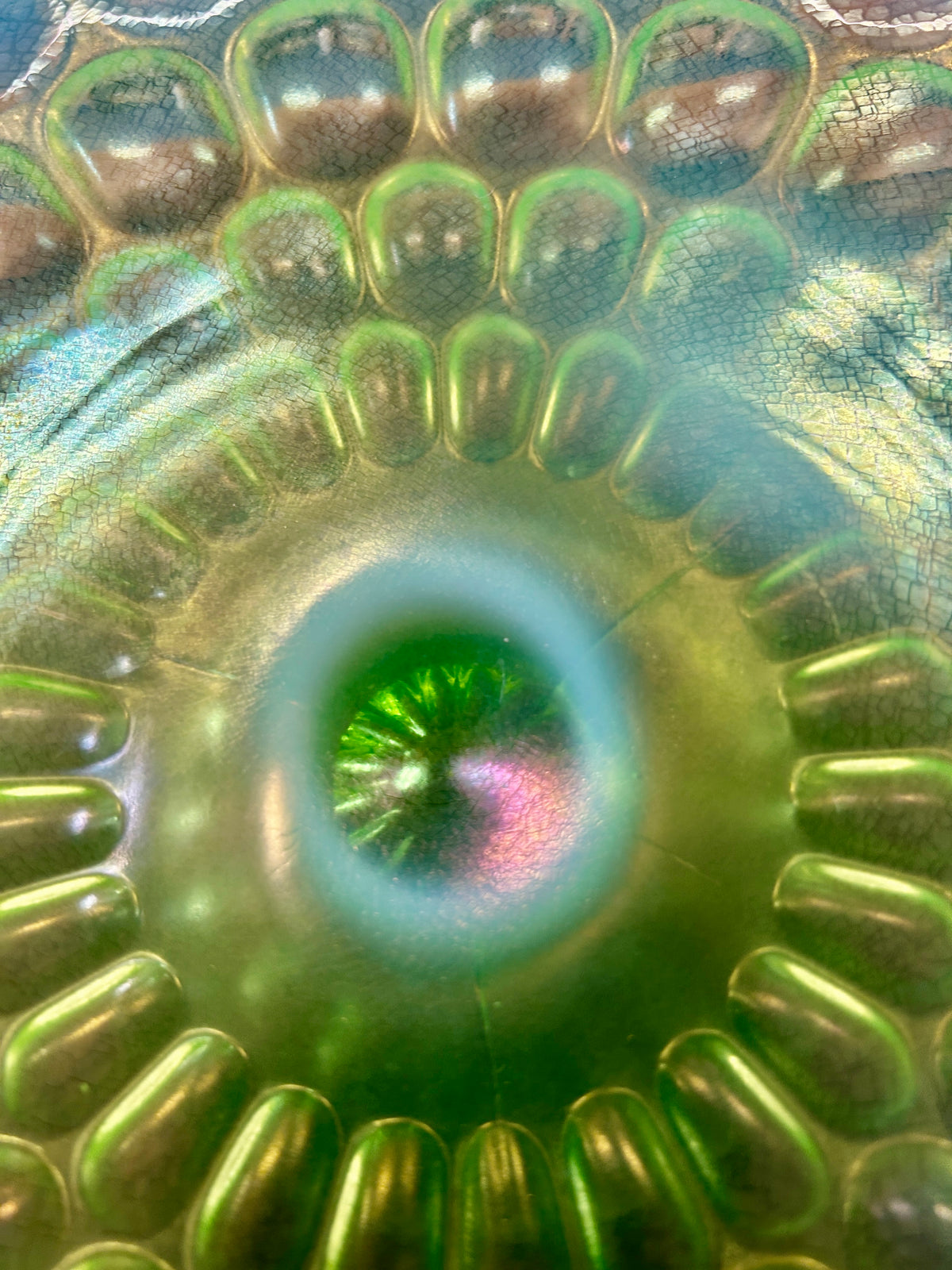 Close-up of green thumbprint cake stand surface with raised dots and central rosette