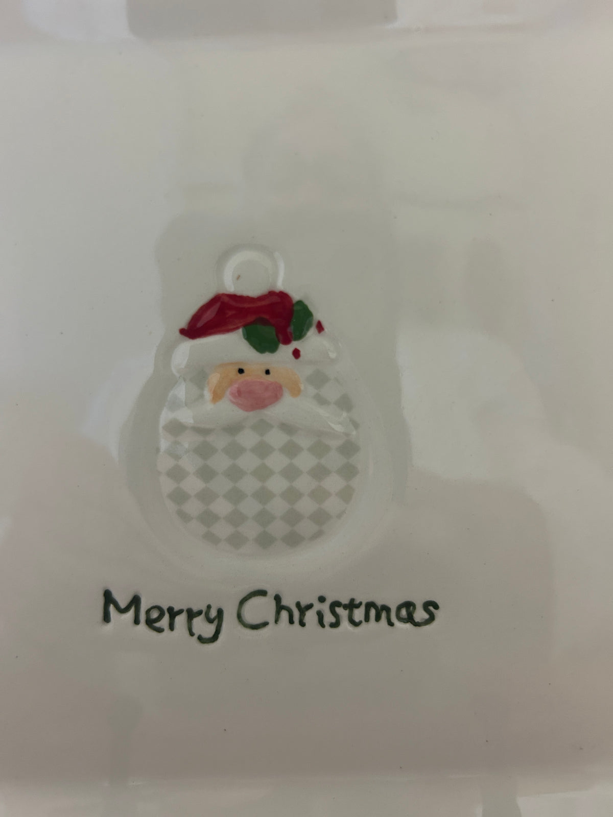 White square plate close-up with Santa face icon and “Merry Christmas” lettering