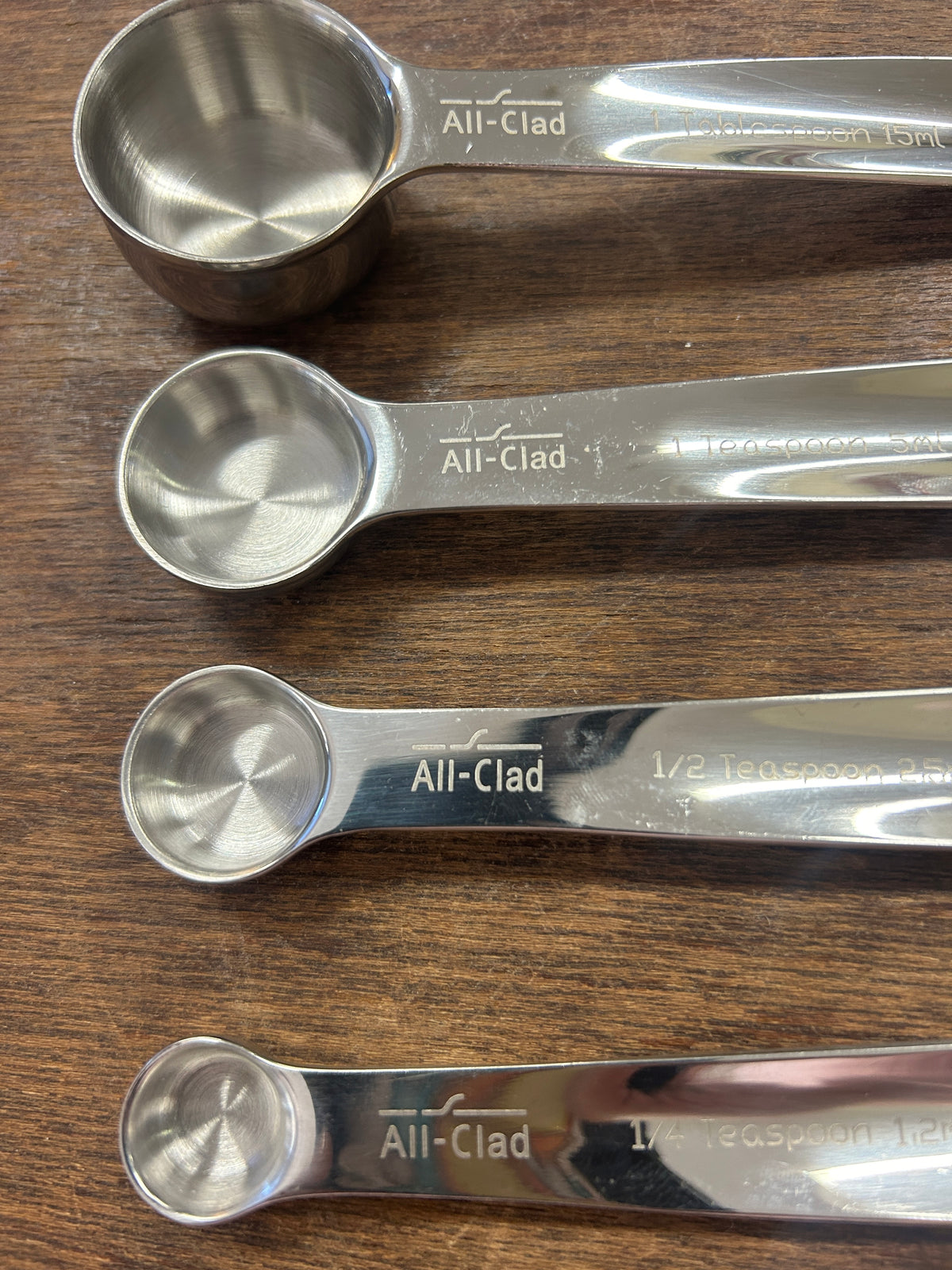 Stainless All-Clad measuring spoons with round bowls and engraved handle markings