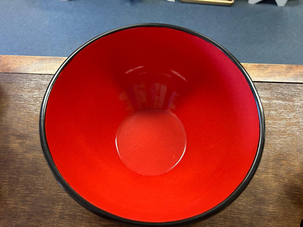 Red ceramic bowl interior with central raised base and black outer rim