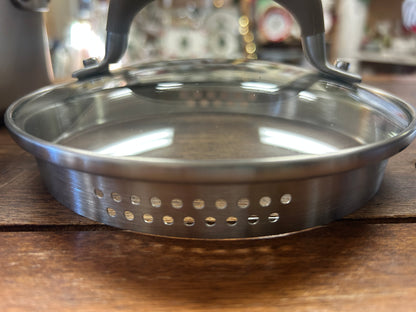 Stainless saucepan rim with evenly spaced pouring holes and rivets