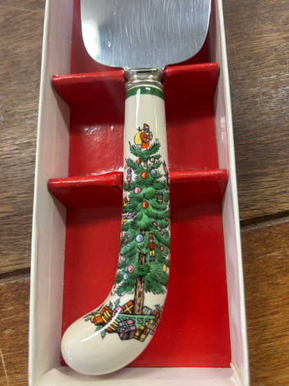 Red Christmas cake server handle with green tree scene and stainless steel blade