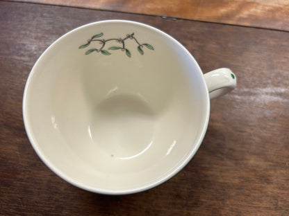 Ceramic Christmas cup with green rim, interior gloss, and painted vine sprig