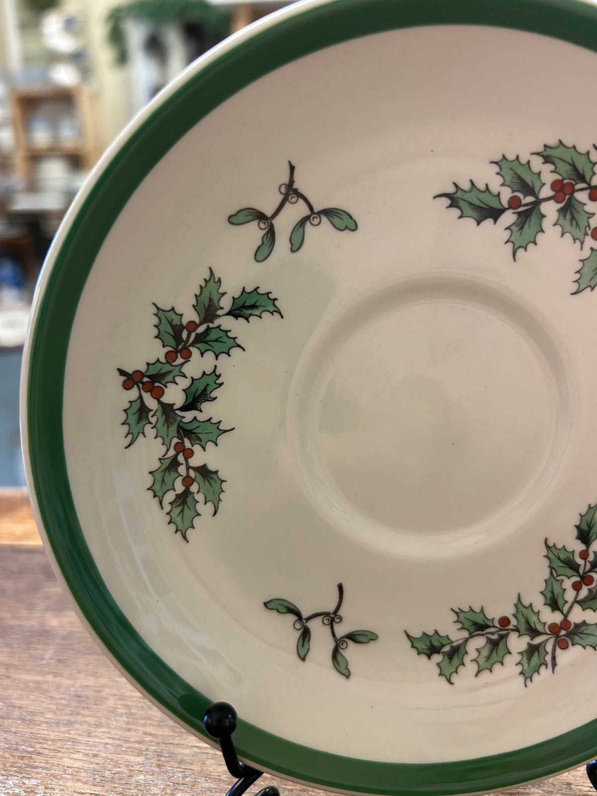 White Spode saucer plate with green rim and holly sprig with berries decoration
