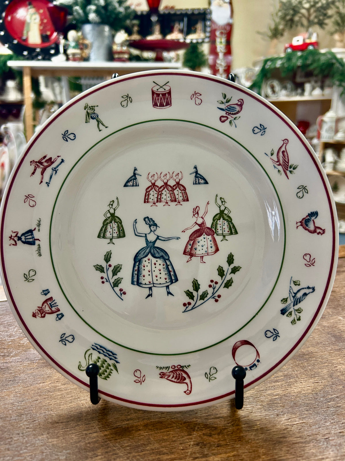Multicolor Christmas decorative plate with dolls and border motifs, white ceramic.